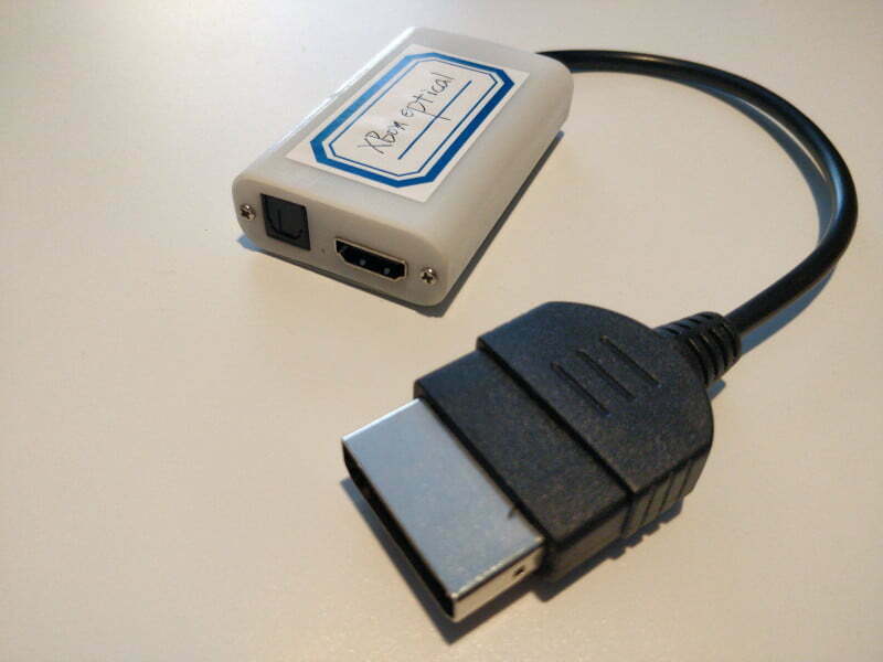 A small white box with HDMI and optical outputs. There's a short lead with an Xbox connector.